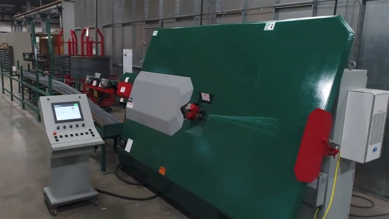 An automatic stirrup bender with its operator console, fed with rebar from coils behind it.